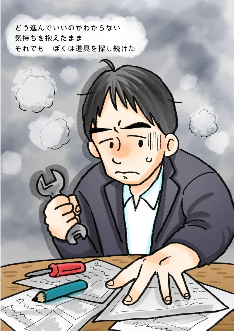 どう進んでいいのかわからない　気持ちを抱えたまま　それでも　ぼくは道具を探し続けた（書類の散らばった机で、スパナを握りしめるぼく）